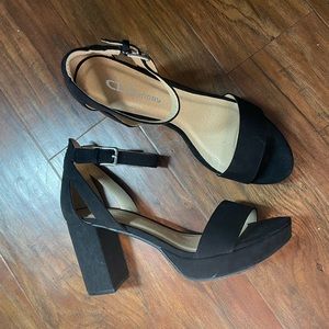 Black platform sandals. Buckle strap around the ankle. Feaux suede material.